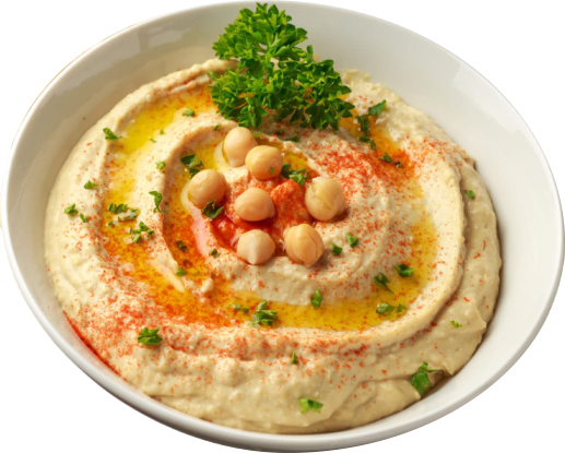 Eine Schüssel cremiger Hummus mit ganzen Kichererbsen, einem Spritzer Olivenöl, gehackter Petersilie und etwas Paprika, garniert mit einem Petersilienzweig.